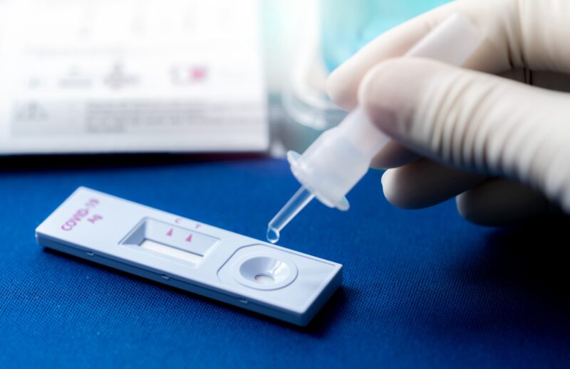 Hand holding sample tube and drops in the test device of covid 19 antigen self test. Antigen test kit for detection of coronavirus infection. Rapid antigen test. Coronavirus diagnosis. Medical device.